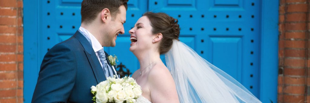 Groom, bride, roses, blue door, https://www.gosfield-hall.co.uk/