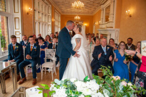 holmewood, ceremony, interior, guests, bride, groom, kiss, table, flowers, clap, chandliers