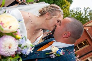 bride, groom, kiss, veil, confetti, close up, wedding attire