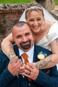 bride, groom, smiles, red tie, tattoo, veil, beard, wedding attire