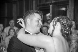 Bride arms around grooms shoulders, eye contact, dancing, close up, black and white image