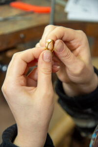 close up hands holding gold ring