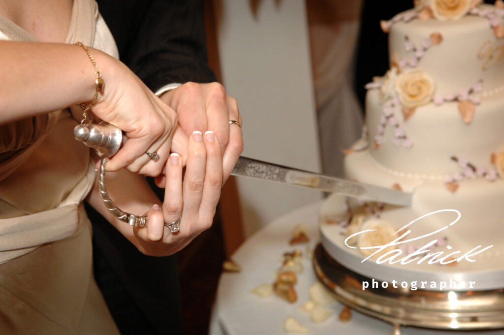 Buckingham gate wedding cutting of the cake, hands knife three tier decorated cake