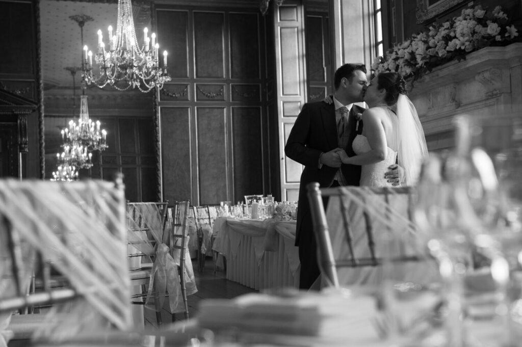 black and white image, interior, Croydon park, groom kisses bride
