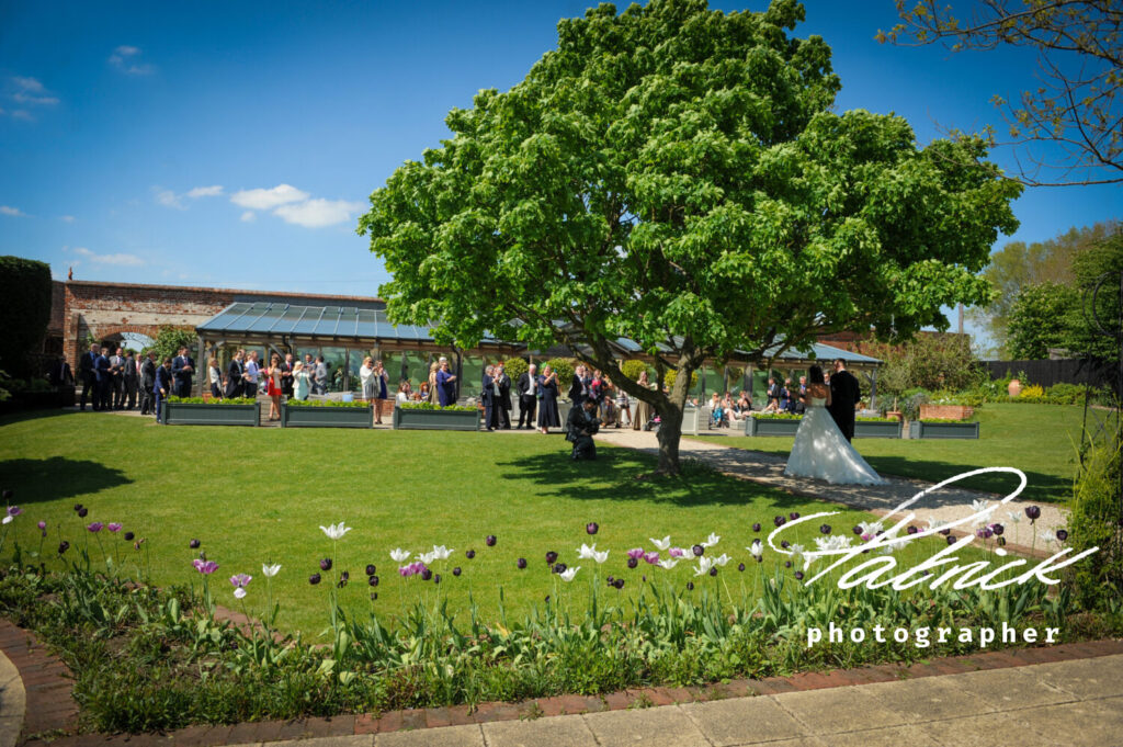 gaynes park, gardens, exterior,bride and groom walking towards venue, spring
